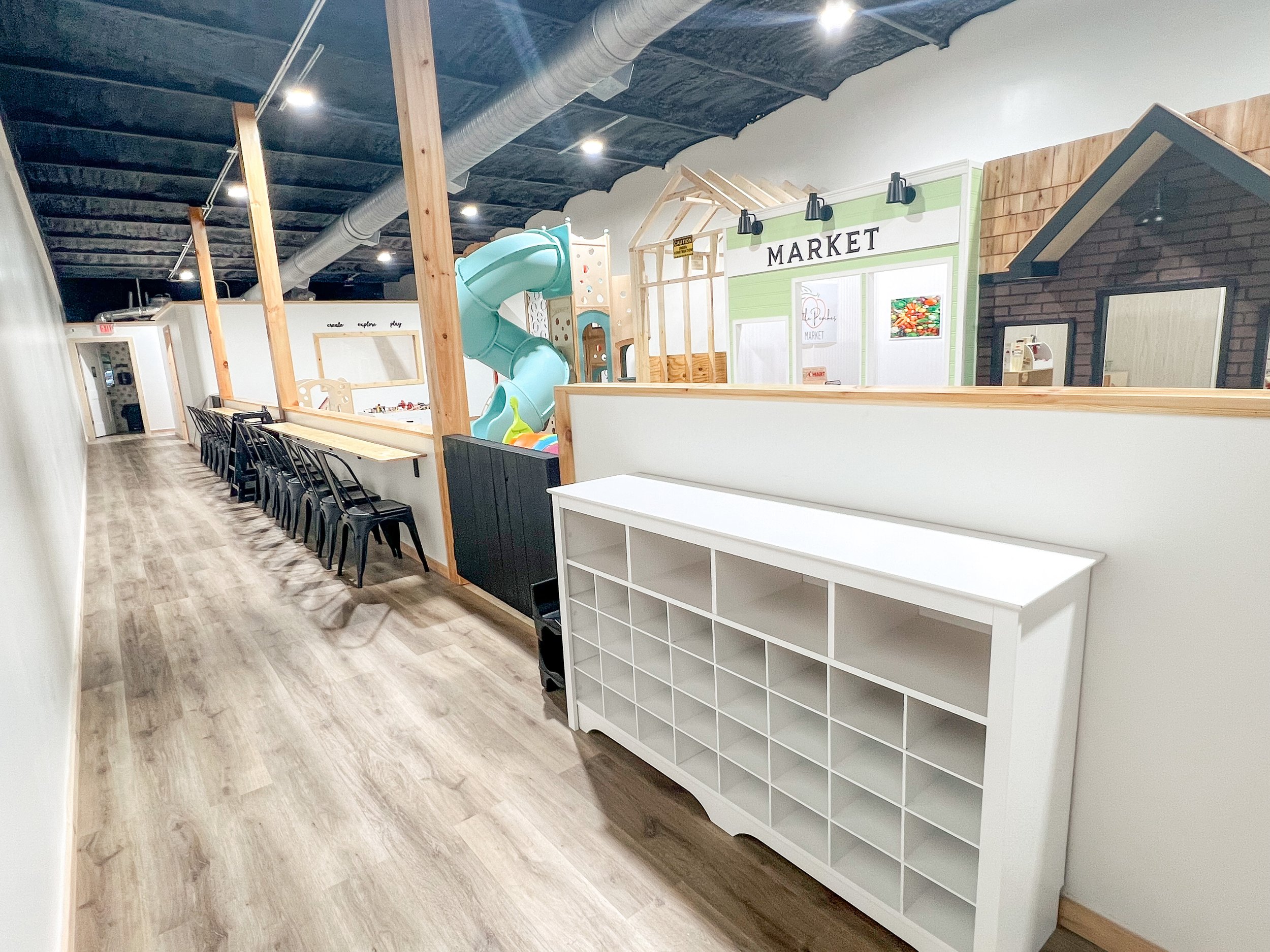 Soft seating area for adults near the play space.
